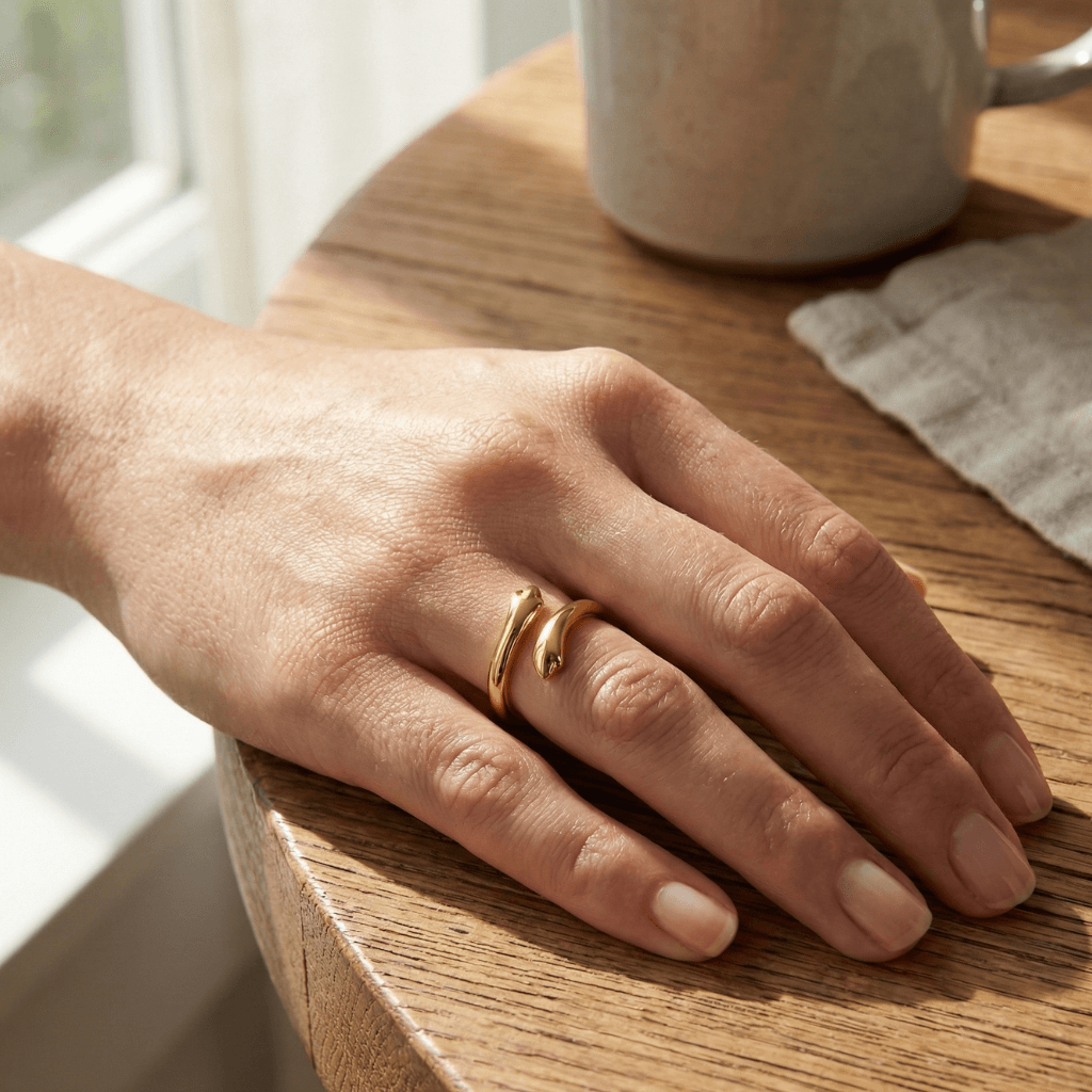 Hand on a table showcasing gold adjustable hug ring 