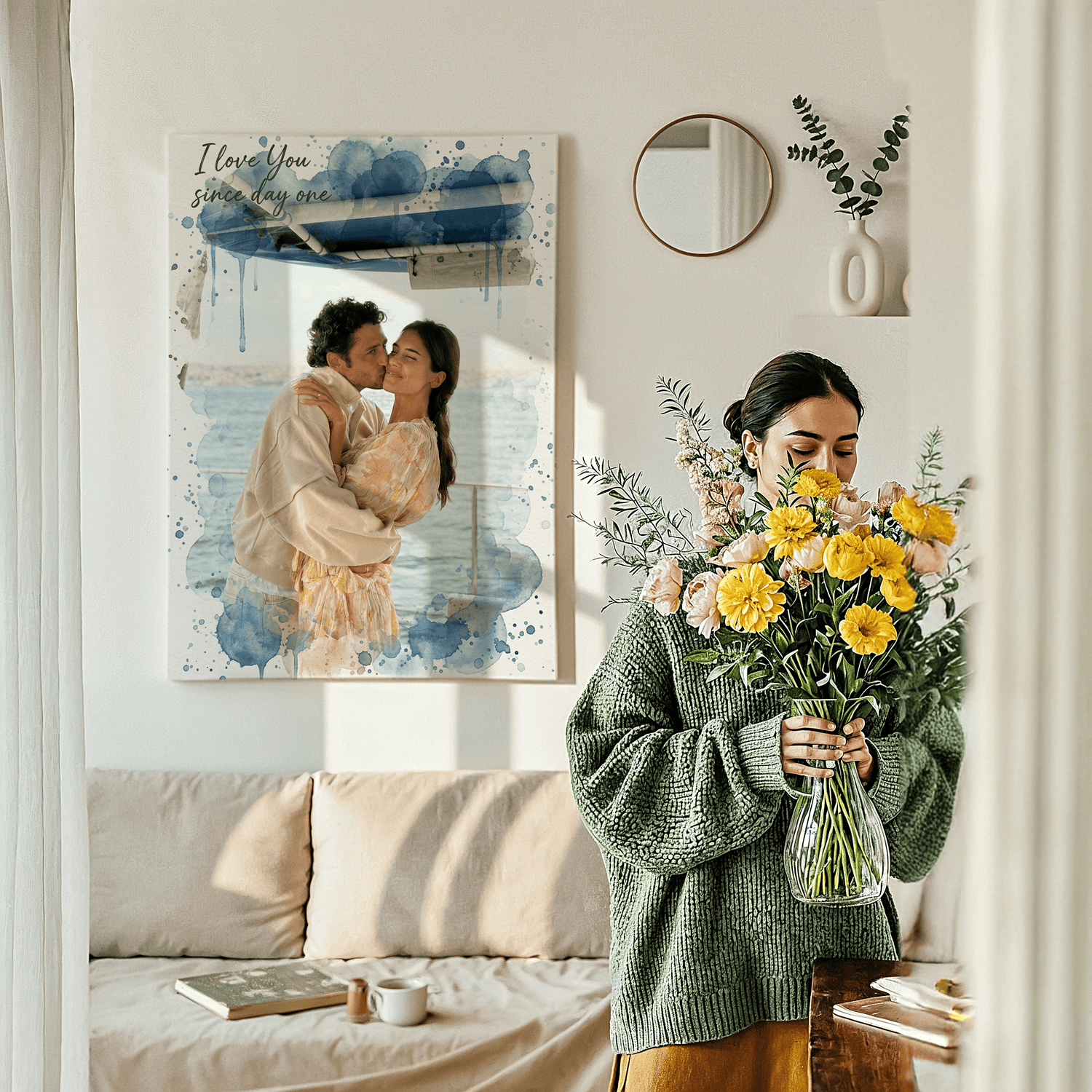 Woman holding flowers next to a large personalized canvas of a couple kissing on a boat, with "I love you since day one" text and blue watercolor splatters.