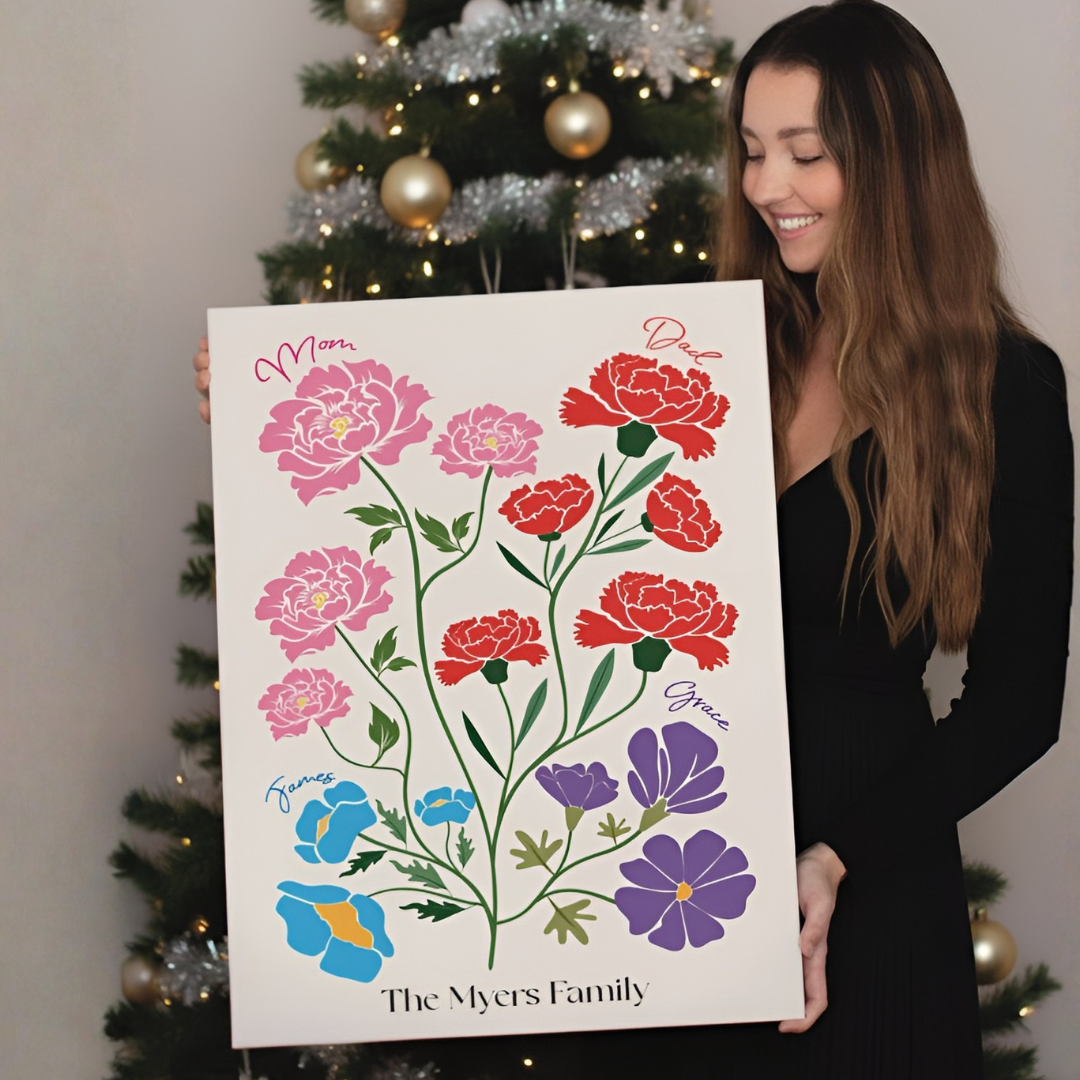 woman smiling in front of a Christmas tree holding an illustrated family garden canvas
