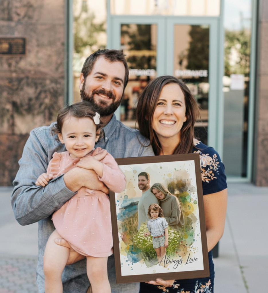 A young family—a mother, father, and toddler—smiling and holding a framed watercolor portrait of themselves. The portrait, titled "Always Love," shows the family in a field with soft blue and green watercolor accents.
