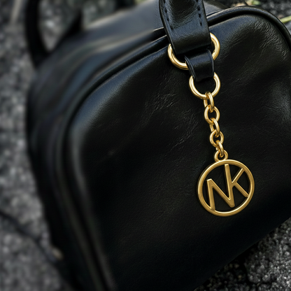gold monogram key chain on black bag