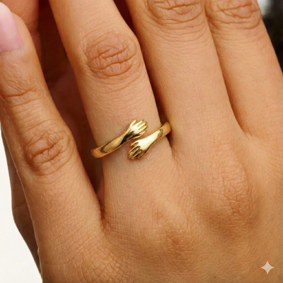 Gold adjustable ring with delicate hand design, close-up on finger