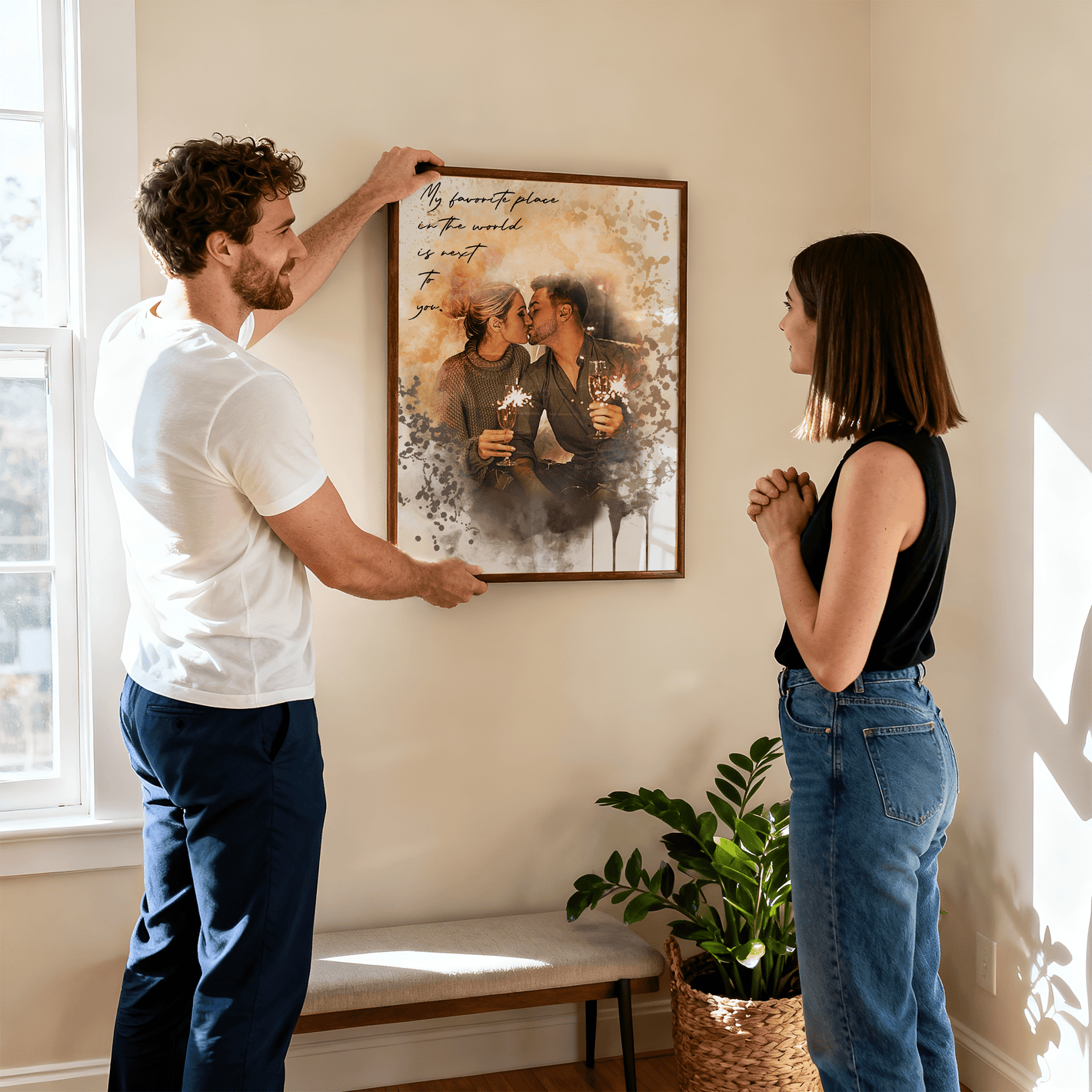 man holding a framed personalized couples portrait against a wall while a woman stands and admires the frame 