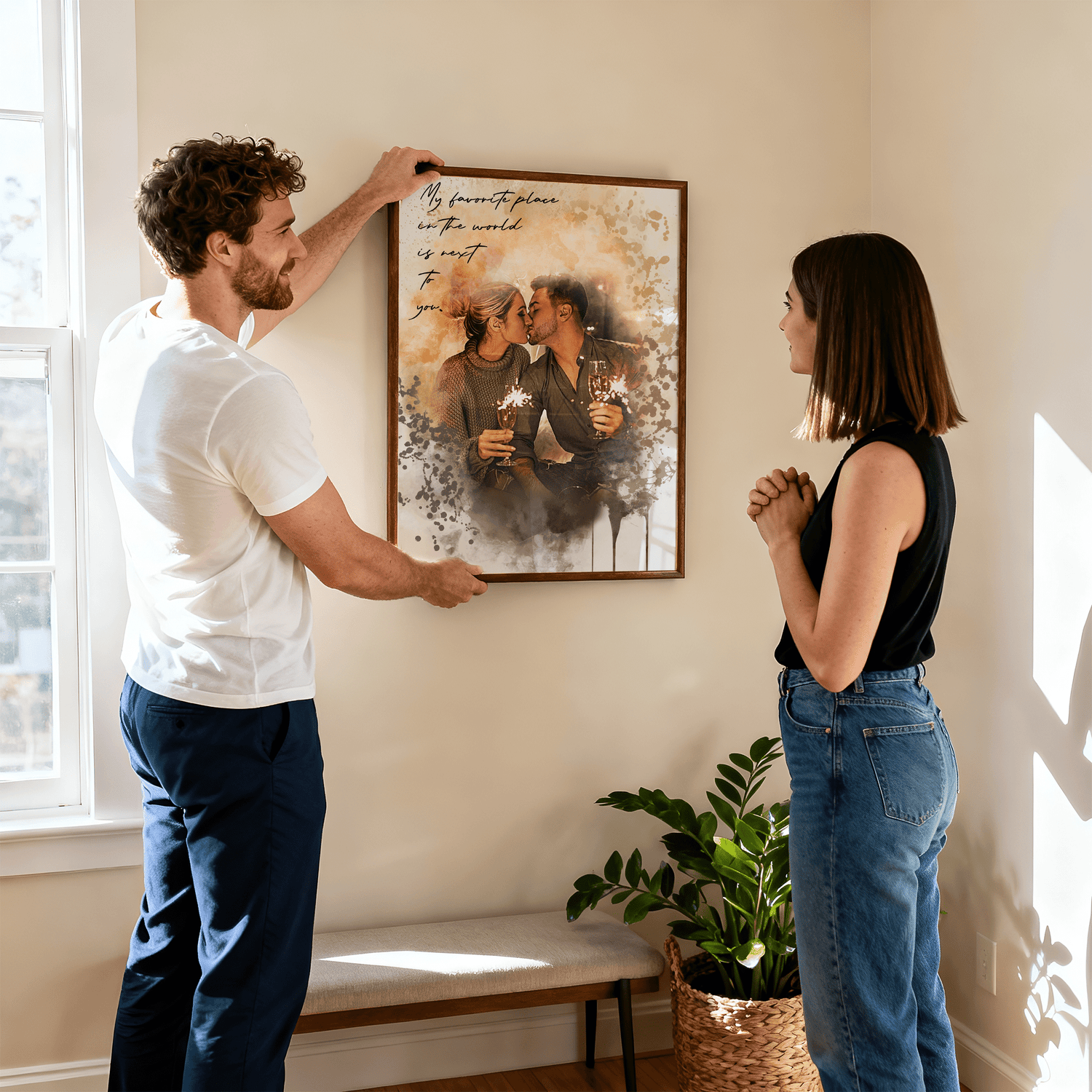 man holding a framed personalized couples portrait against a wall while a woman stands and admires the frame 