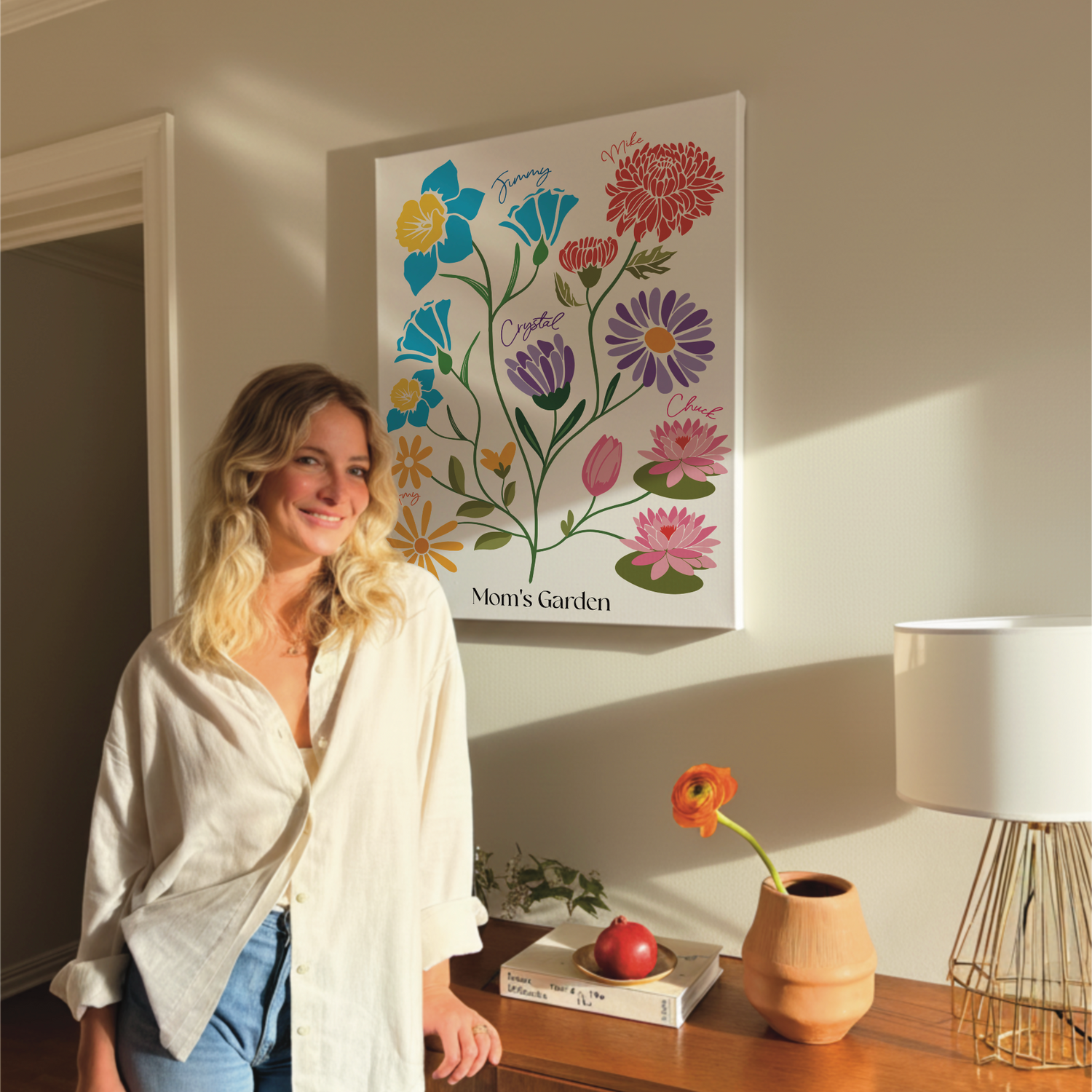 woman standing in front of a personalized birth flower family garden that's hanging above a dresser 