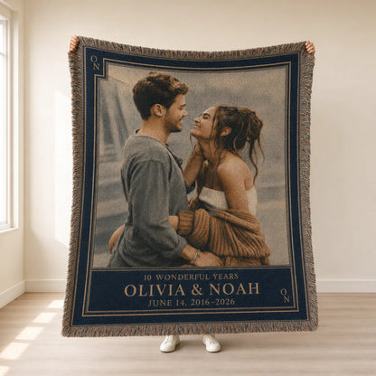 Anniversary couple woven blanket in the Golden Years navy and gold design held up, with monogram corners, names and year range