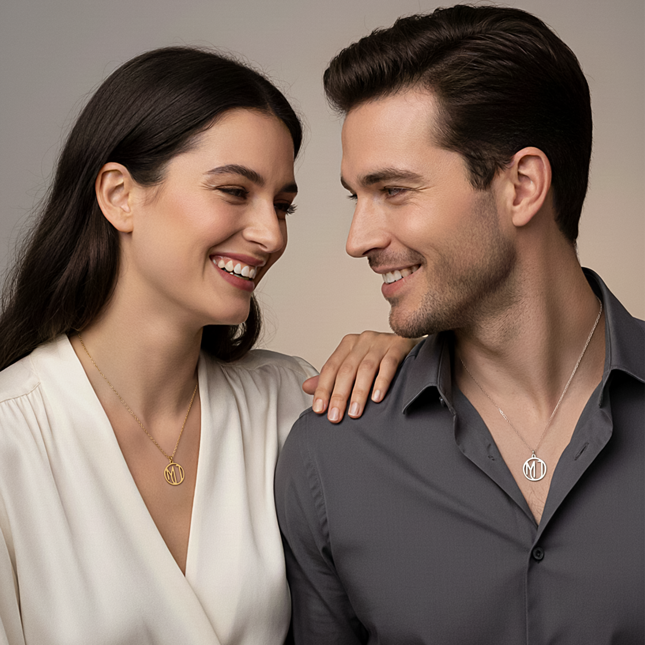 Man and woman smiling wearing monogram necklaces 