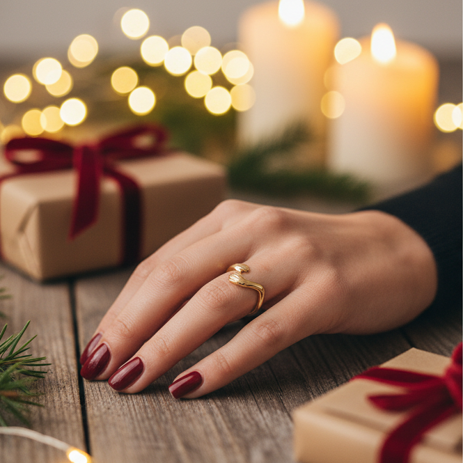 close up of adjustable gold hug ring on a hand next to wrapped presents 
