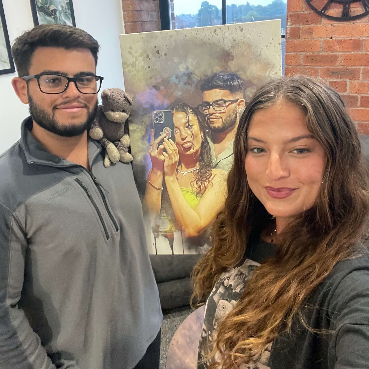couple taking a selfie and holding a personalized couples portrait  