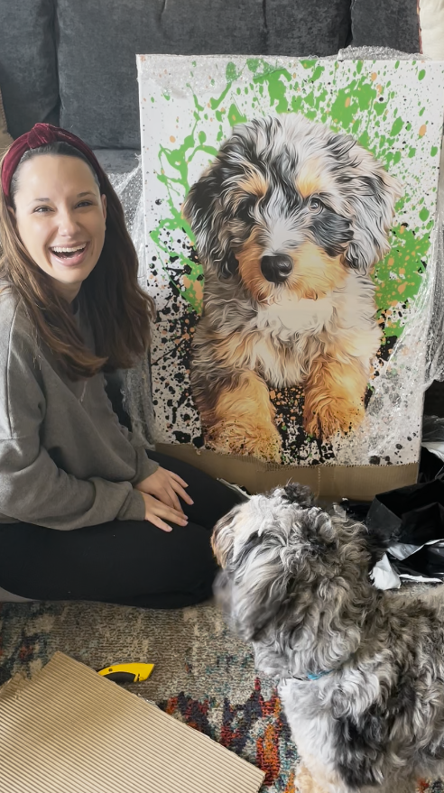 woman smiling and unboxing her personalized pet portrait 