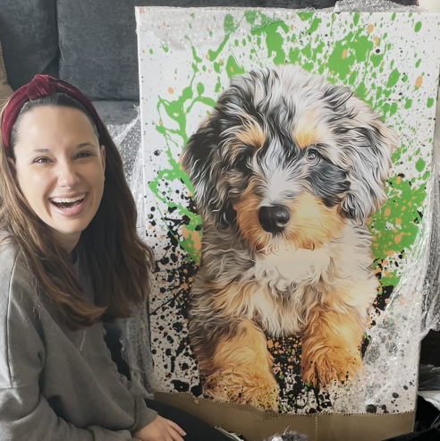 woman smiling while holding a personalized pet art canvas 