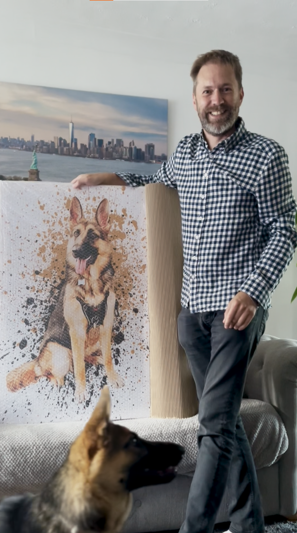 man smiling and holding personalized pet portrait pf his German Shepard 