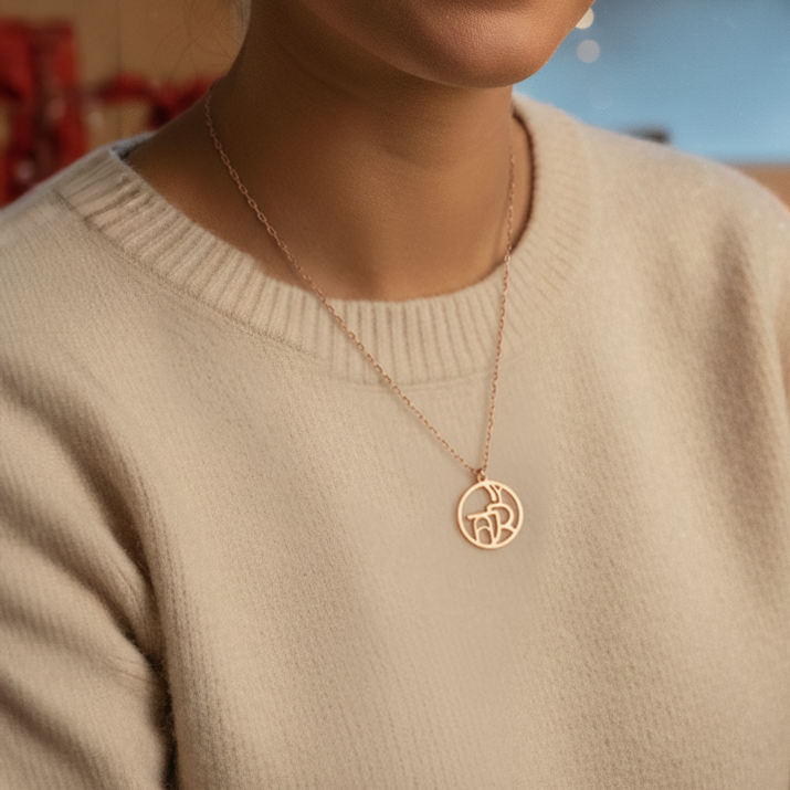 Close up of woman's neck wearing rose gold monogram necklace 