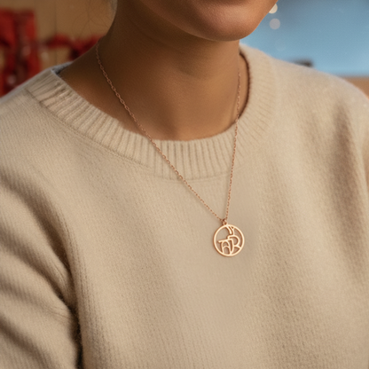 Close up of woman's neck wearing rose gold monogram necklace 