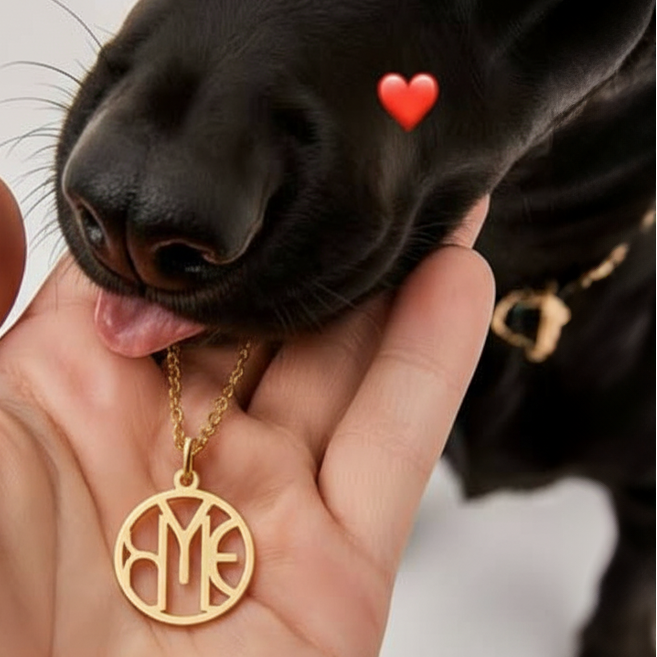 hand holding dogs jaw and a gold monogram necklace