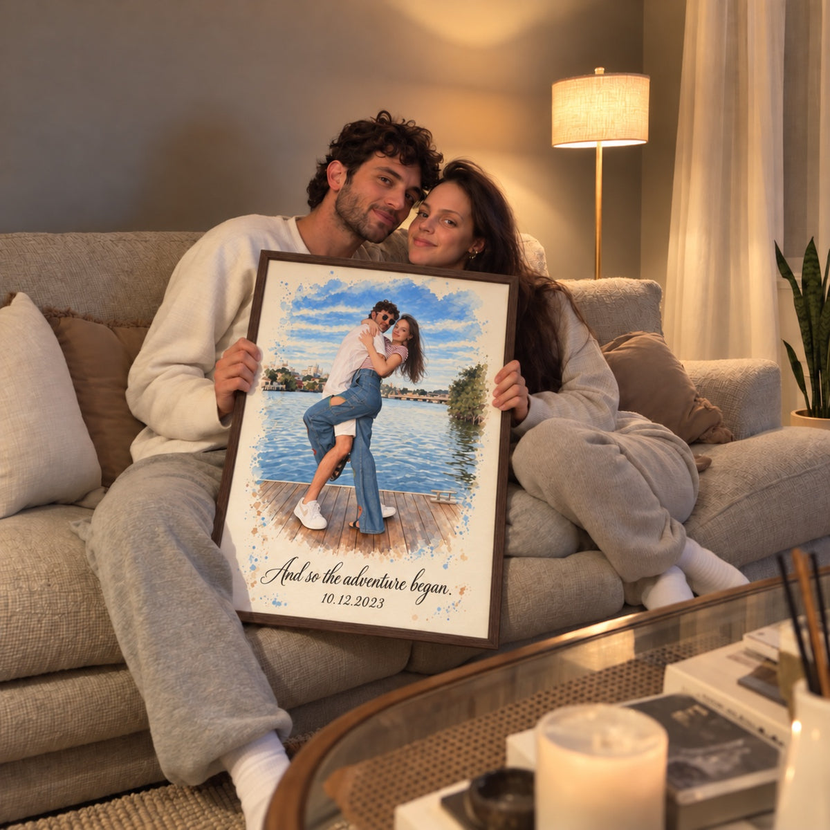 Couple on the couch holding their framed portrait 'And so the adventure began'