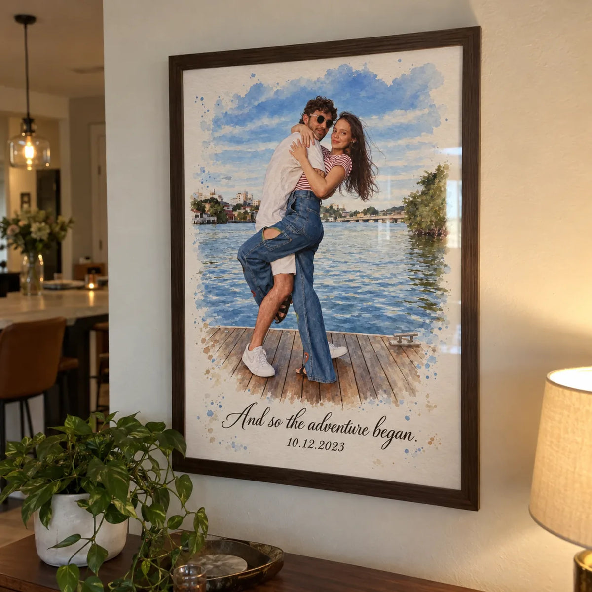 A framed watercolor portrait of a couple on a lake dock hangs on a wall.