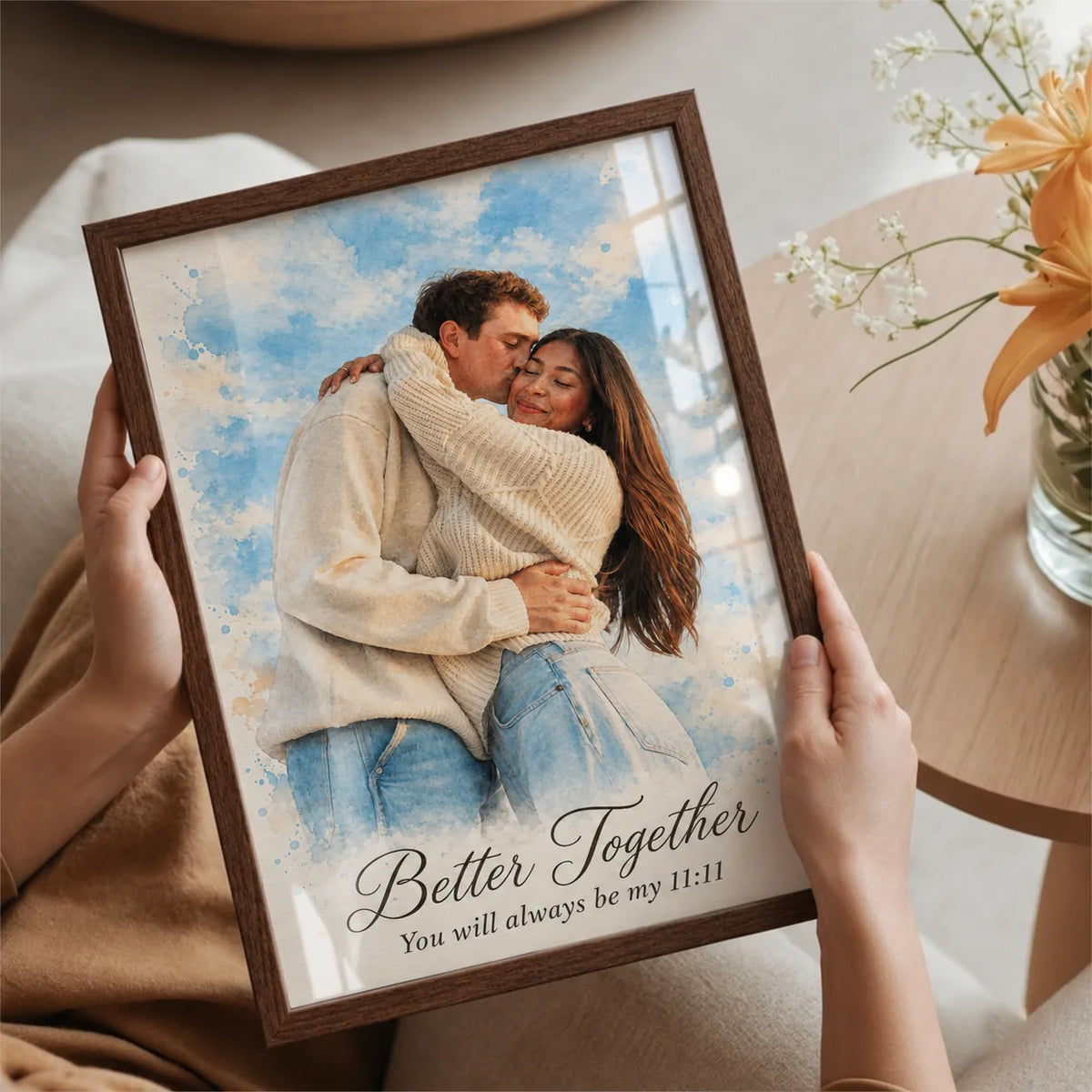 Hands hold a framed watercolor portrait of a couple hugging, titled Better Together.