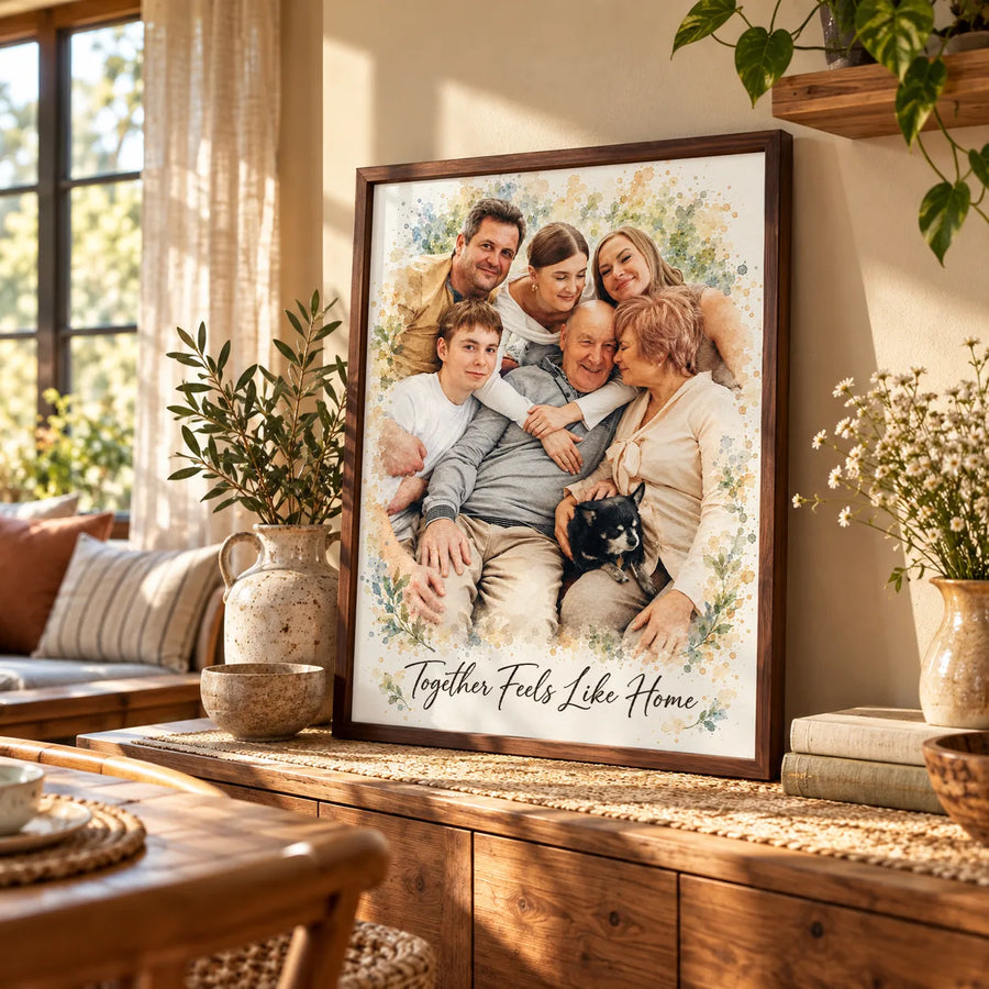A framed watercolor portrait of three generations hugging, with a small dog, leans on a wooden sideboard.