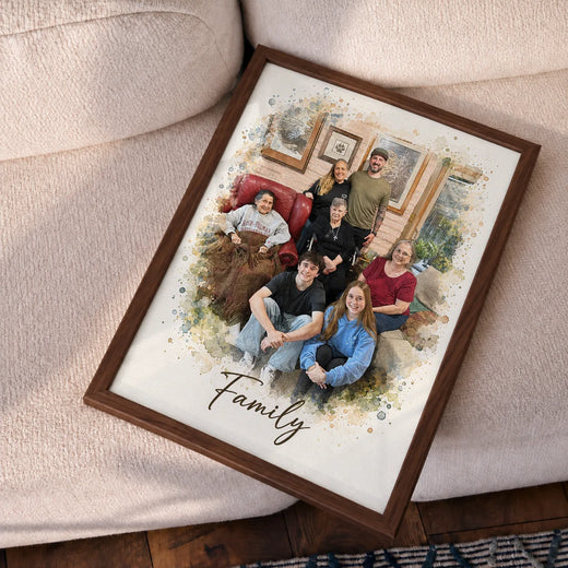 A framed watercolor portrait of a large family tilted on a cream sofa