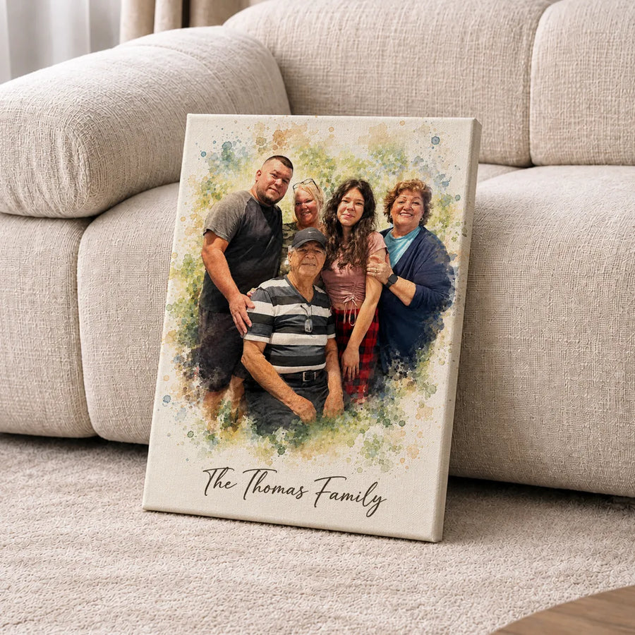 A canvas watercolor portrait of five family members leans on a cream sofa.