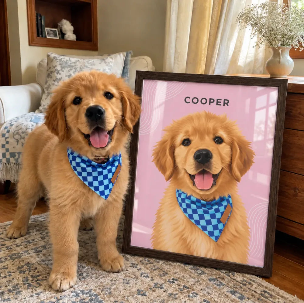 A happy golden retriever puppy in a checkered bandana sits next to its own framed portrait.